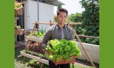 youht-led urban farming grants; young man holding box of lettuce on urban farm