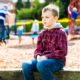 improving care for children with add/adhd and tourrete's; child sitting alone at playground