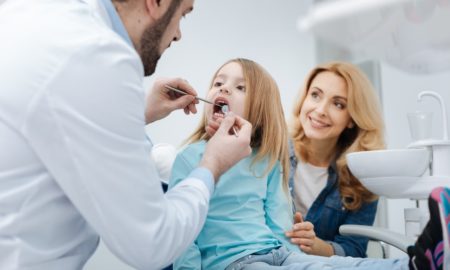 community dental care and education grants; young girl at dentist's office with mom