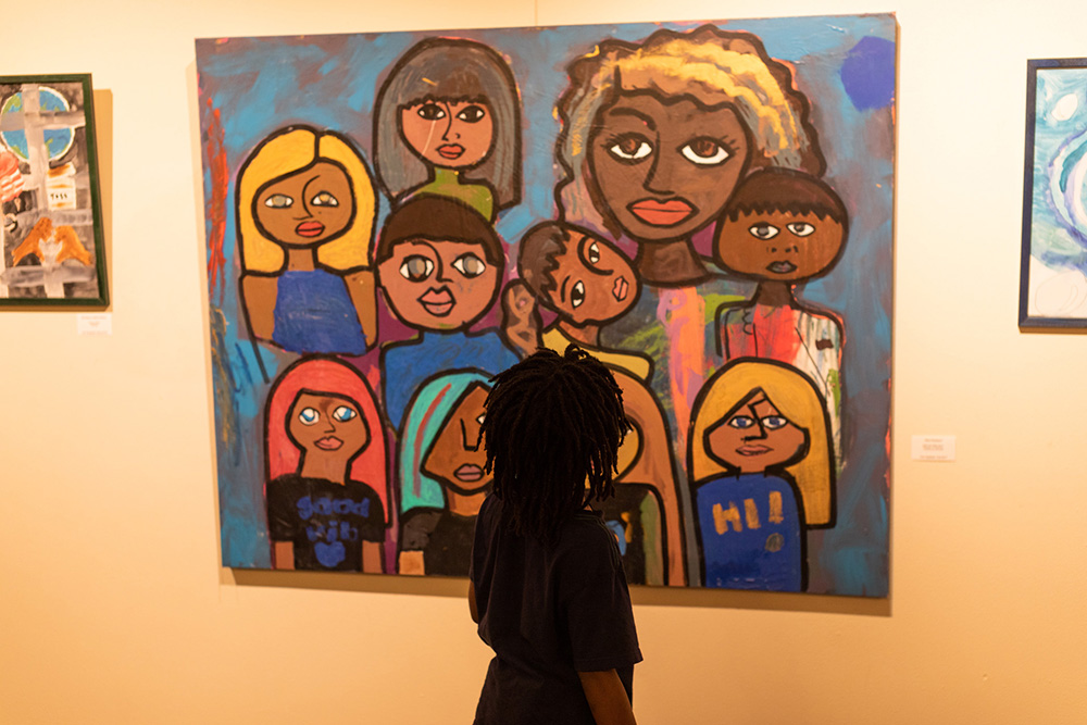 Boys & Girls Clubs: Silhouette of girl looking at bright painting of girls.