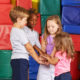 SEL: 4 children stacking their hands in kindergarten gym
