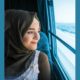 A right to be heard report; young migrant girl in hijab on train