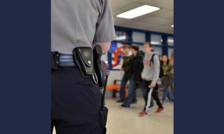 School Safety report; armed security officer in school hallway