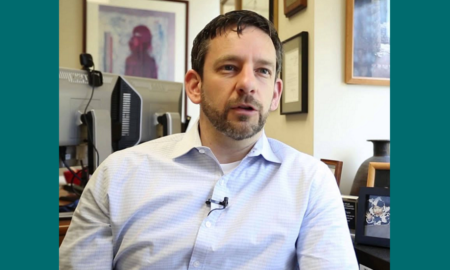 Newsmaker Casey Trupin headshot; man sitting in office in collared shirt