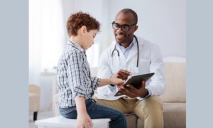 child healthcare improvement grants; doctor showing child info on tablet