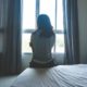 girls/women sexual exploitation prevention/intervention grants; young woman sitting on bed looking out window