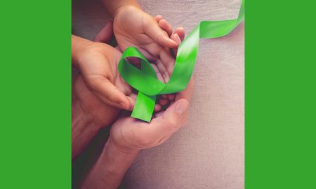 children's mental health grants; adult and children's hands holding green mental health awareness ribbon