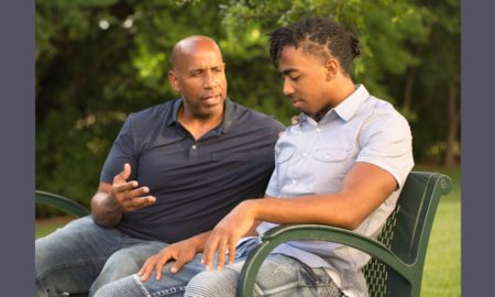 youth mentoring for preventing delinquency grants; man mentors young african american man on park bench