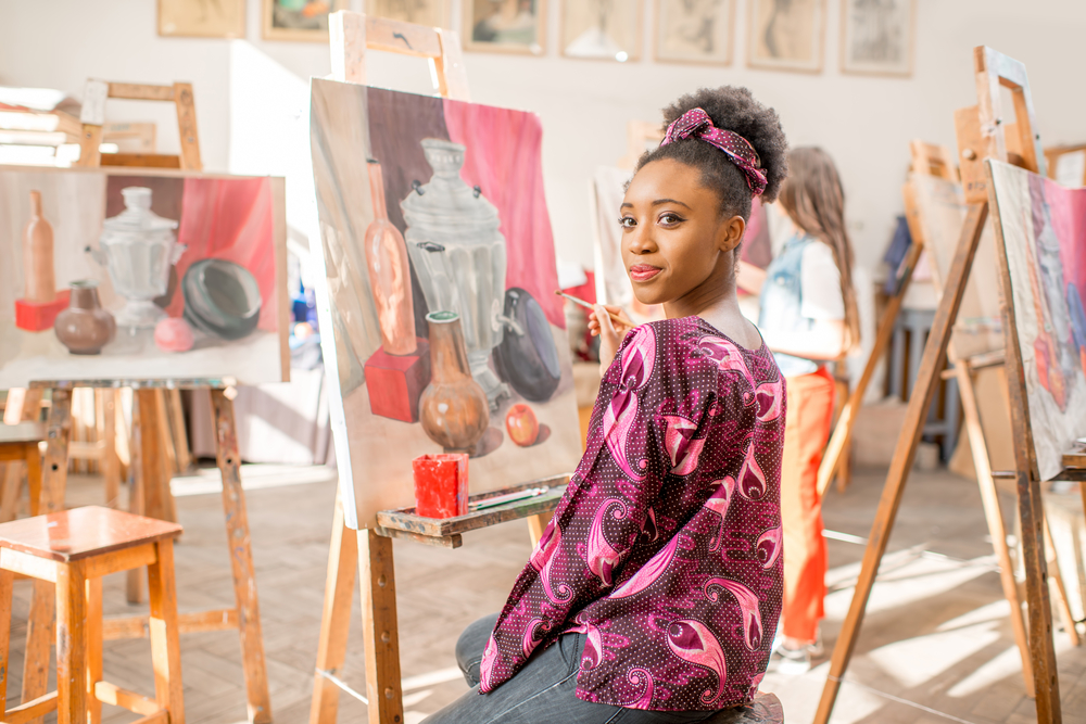 art: young student sitting with still life painting at studio 
