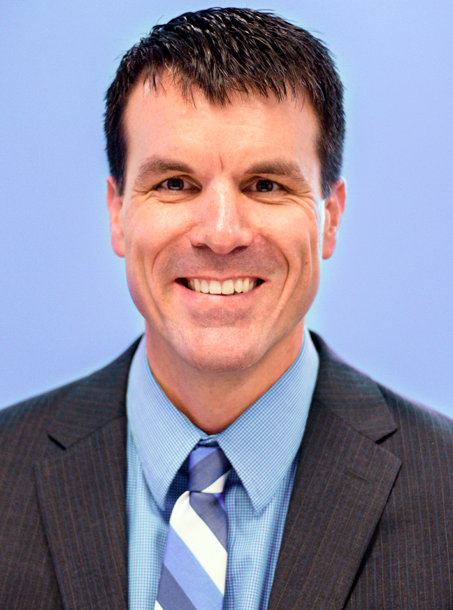 Greg Zweber newsmaker headshot; man in suit tie smiling at camera