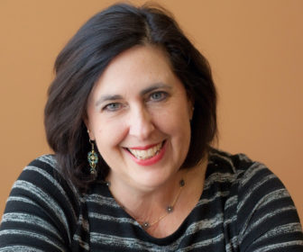 summer learning: Lynn Gatto (headshot), associate professor in Warner School of Education and Human Development, smiling woman with shoulder-length dark hair, earrings, necklace, striped top.