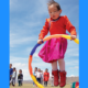 A World Ready to Learn, Early Chidhood Education Report; young ethnic girl playing with hoop in front of blue sky