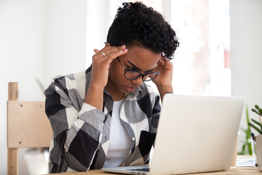 ACEs: Stressed focused african american woman concentrating doing difficult online computer work, frustrated black female student looking at laptop feeling headache tired of study learning overwork 