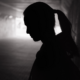 Trends in youth suicide report image; silhouette of young sad woman in tunnel