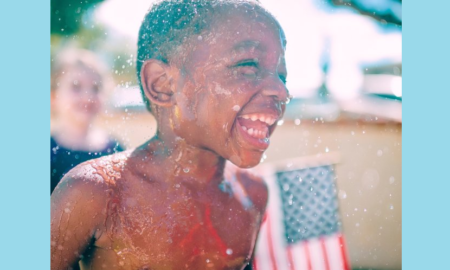children's environmental health grants; young black child playing outside in water
