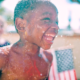 children's environmental health grants; young black child playing outside in water