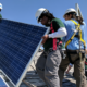community environment and sustainability grants; workers installing solar panels on clear day