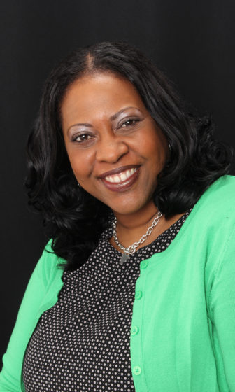 Netflix: Aprill O. Turner (headshot), communications director of Campaign for Youth Justice, smiling woman with shoulder-length black hair in black outfit, earrings, necklace.
