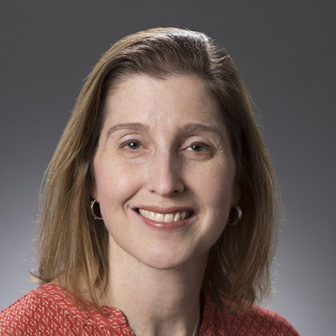 Leslie Gross (headshot), director of the Jim Casey Youth Opportunities Initiative, smiling woman with light brown hair, earrings, orange print top. 