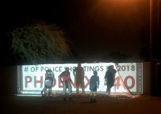 Phoenix: Silhouettes of people in front of banner.