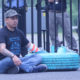 ICE: Man sits on ground next to blue tire in front of fence