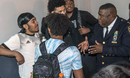NYPD: Young men of color cluster around police officer of color.