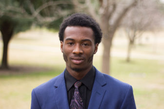 Charles Batiste (headshot), youth advocate and research assistant, young man with sideburns, blue suit, black shirt, paisley tie