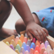 connecticut early care, education and youth development grants; child playing with chalk in daycare