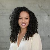 homeless: Aisha Canfield (headshot), director of Ceres Policy Research, smiling woman with long black curly hair, white blouse.