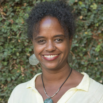 colleges: Rashida Crutchfield (headshot), associate professor at California State University, smiling woman with black hair, earrings, necklace, yellow top