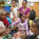 children living in high poverty, low opportunity neighborhoods report; group of black school children in class with teacher