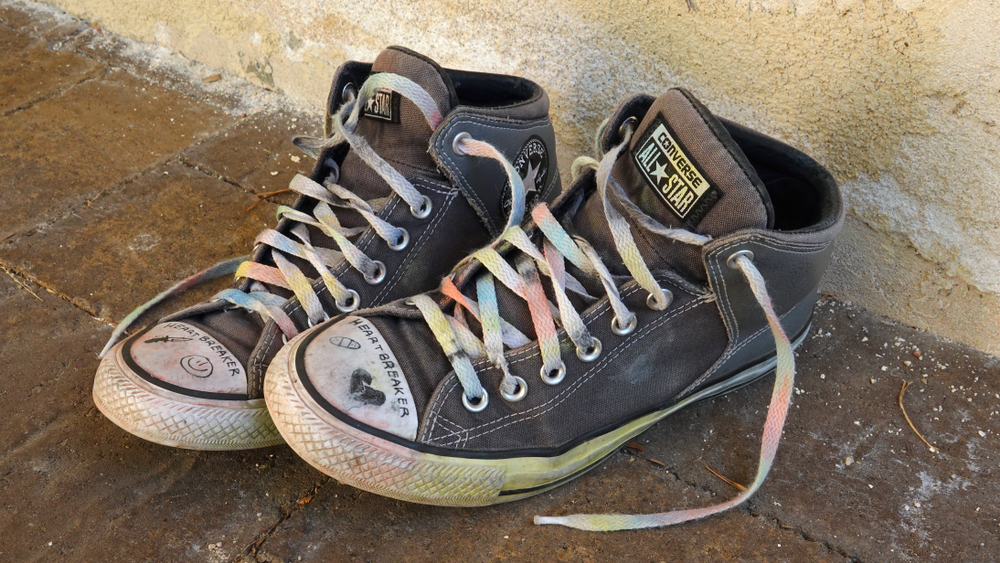 homeless: A teen's well-worn, drawn on Converse All-Star sneakers, with the laces painted in rainbow colors