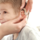 deaf or hard-of-hearing child healthcare grants; young boy receiving hearing aid