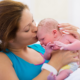maternal pediatric health grants: mother in hospital kissing her newborn