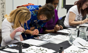 youth foreign language learning grants; teacher teaching students to write Asian script