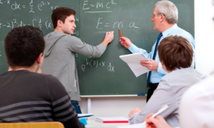 youth summer math program grants; student doing math on blackboard with teacher