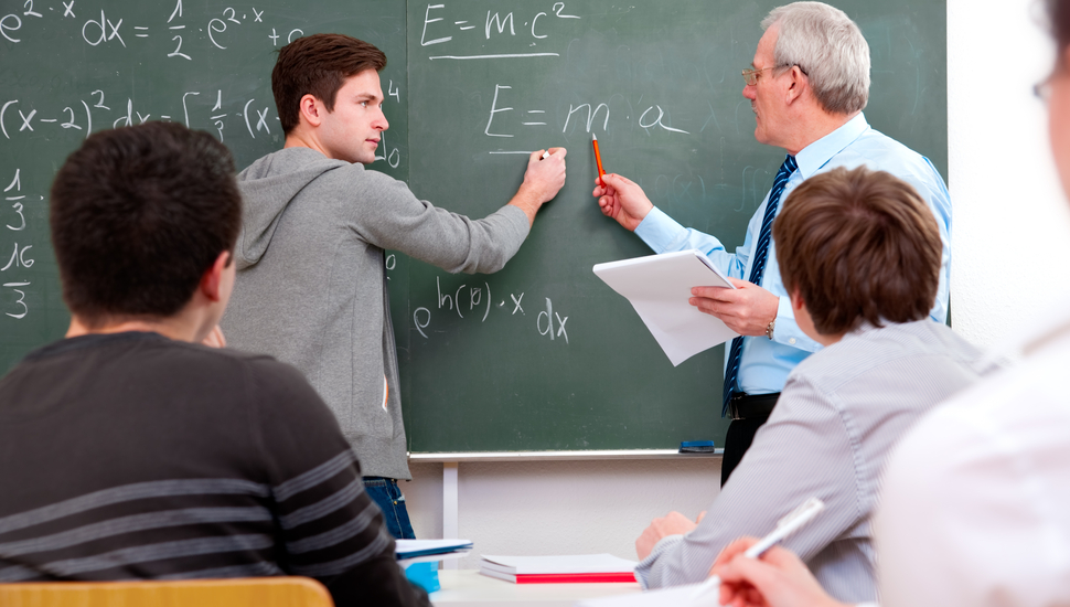 youth summer math program grants; student doing math on blackboard with teacher