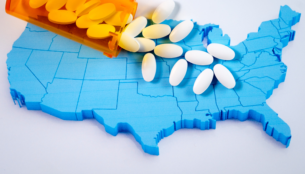 rural opioid abuse; bottle of pills being spilled over map of U.S.
