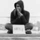 homeless and street youth services grants; homeless teen sitting on ground with help sign