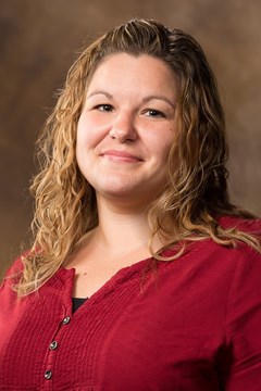 gun safety: Johanna Thomas (headshot), assistant professor at University of Arkansas, woman with long light brown hair, red top