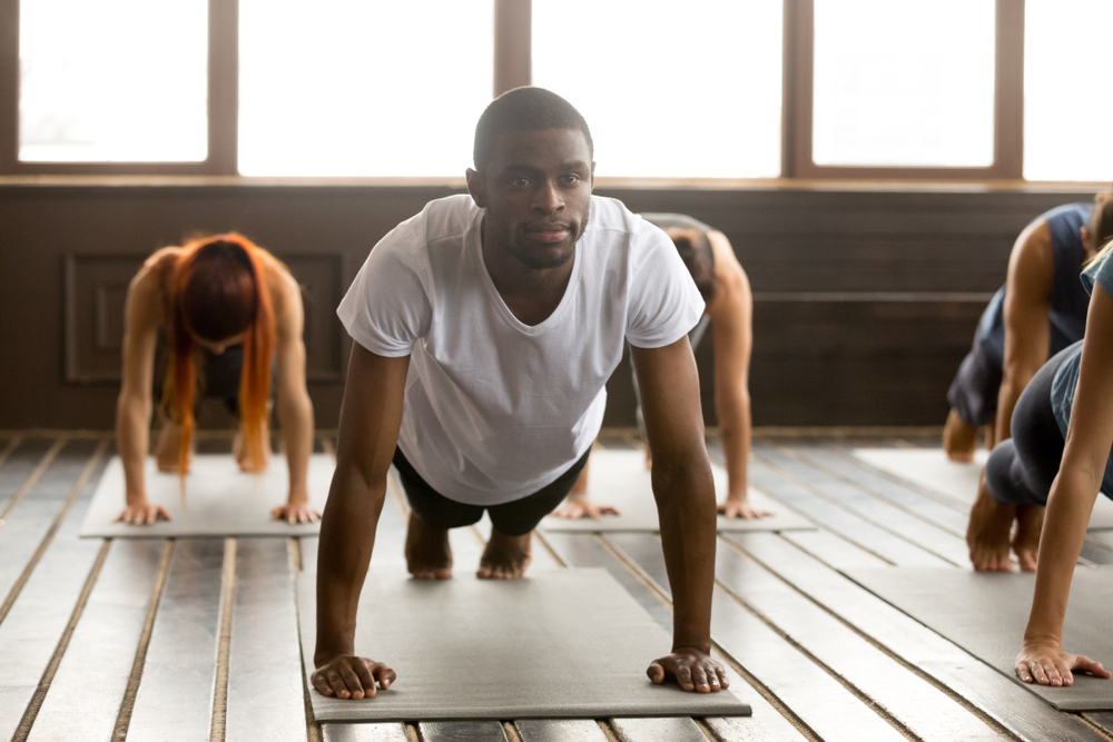 HOPE Court: young black man in yoga class standing in plank pose