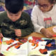 tool: Little boy and girl look at picture book; girl holds marker
