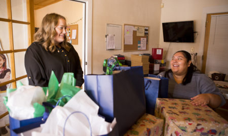Santa Fe: 2 women smile at each other as they wrap very large presents