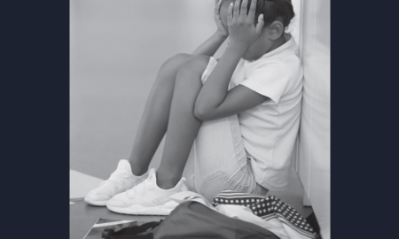 Ring the Alarm: Crisis of Black Youth Suicide Report; young, sad black girl sitting in corner with head in hands