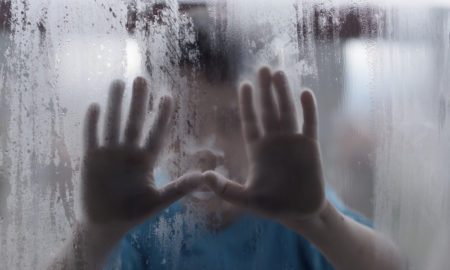 foster care: children's hands on the misted window
