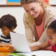 early childhood educator grants; female teacher smiling while teaching young students