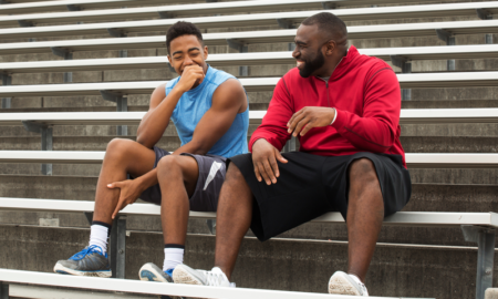 Mentoring for preventing and reducing substance use report; black teen male and mentor talking and laughing on bleachers