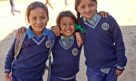 girls development and leadership grants; three young girls smiling in school uniforms