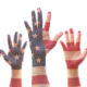Conflic resolution, youth leadership and civic engagement grants: raised hands of young people colored like american flag