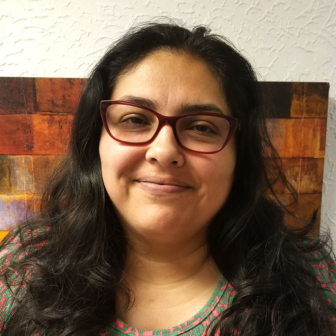 kin caregiver: Leandrea Romero-Lucero (headshot), smiling woman with long dark hair, glasses, patterned top